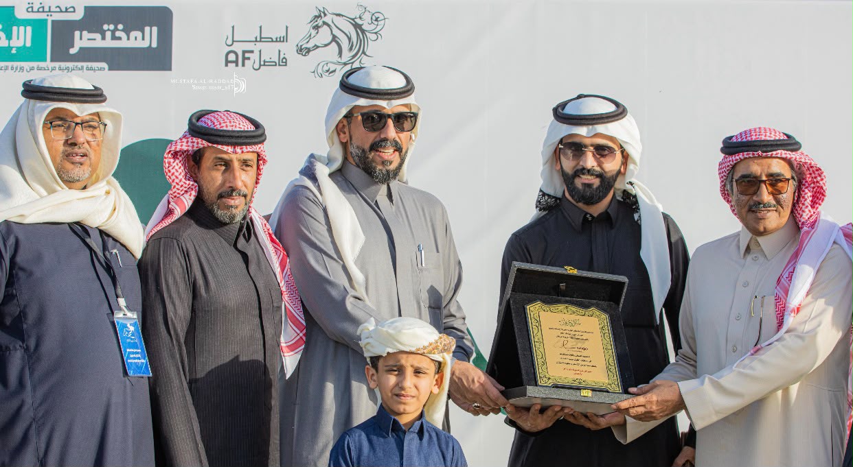 Lungo presenting a commemorative plaque at a horse racing event